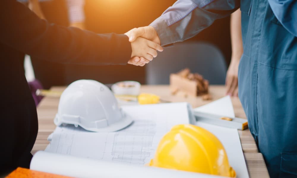 Two people shaking hands as they finalize a deal after learning how to find good contractors